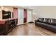 Inviting living room with hardwood floors, a modern TV stand, and a comfortable leather sofa at 465 Miller Ave, Brighton, CO 80601