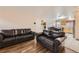 Inviting living room area leading to the kitchen, featuring hardwood floors and comfortable couches at 465 Miller Ave, Brighton, CO 80601