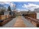 Backyard featuring a wooden walkway, gravel, garden boxes, and secure fencing for privacy and gardening at 1445 Ash St, Denver, CO 80220