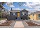 Charming gray brick home with a wooden front door, garden beds, and well-maintained landscaping at 1445 Ash St, Denver, CO 80220