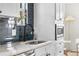 Bright kitchen featuring a tiled backsplash, stainless steel appliances, and white cabinets at 1445 Ash St, Denver, CO 80220