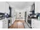 Open-concept kitchen with stainless steel appliances and white cabinets, flowing into a dining area at 1445 Ash St, Denver, CO 80220