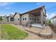 Exterior view of house, pea gravel and grass yard and covered back porch with black railing at 3336 Goodyear St, Castle Rock, CO 80109