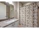 Bright bathroom featuring a granite countertop, decorative mirror, and a stylish shower curtain at 3336 Goodyear St, Castle Rock, CO 80109