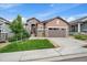 Charming home featuring manicured lawn, stone accents, and a convenient two-car garage, all under a beautiful blue sky at 3336 Goodyear St, Castle Rock, CO 80109