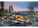 Beautiful backyard with a stone water feature, seating area, and lush landscaping perfect for outdoor entertaining at 16244 Thunder Cat Way, Monument, CO 80132