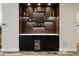 Home bar with black cabinets, white countertop, lit display shelves, and a built-in beverage refrigerator at 16244 Thunder Cat Way, Monument, CO 80132