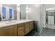 Modern bathroom with double vanity, sleek fixtures, and a glass-enclosed shower near the walk-in closet at 16244 Thunder Cat Way, Monument, CO 80132