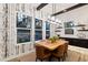 A modern dining room boasts bright windows, stylish wallpaper, and a contemporary chandelier at 16244 Thunder Cat Way, Monument, CO 80132