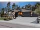 Charming single-Gathering home featuring a three-car garage, stone accents, and manicured landscaping at 16244 Thunder Cat Way, Monument, CO 80132