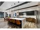 A modern kitchen features a large island with seating, pendant lighting, and sleek cabinetry at 16244 Thunder Cat Way, Monument, CO 80132