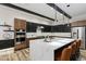 Modern kitchen boasting a large island, two-tone cabinets, stainless steel appliances, and stylish pendant lighting at 16244 Thunder Cat Way, Monument, CO 80132