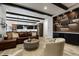 An open living room features exposed beams, a comfortable leather sofa, and a stylish bar area at 16244 Thunder Cat Way, Monument, CO 80132