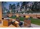 Outdoor patio with cozy seating area and fire pit, surrounded by lush landscaping and a stone retaining wall at 16244 Thunder Cat Way, Monument, CO 80132