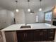 Kitchen island with sink, modern appliances, and dark cabinets provides ample storage at 9220 Wilde Ln # 102, Parker, CO 80134