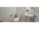 Powder room with pedestal sink, toilet, and wood-look tile floor at 3929 S Quemoy Ct, Aurora, CO 80018