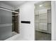 Bathroom with tiled shower and view to open closet with shelving and cabinetry at 2078 Goldfinch Ct, Longmont, CO 80503