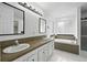 Bathroom with double sink vanity, soaking tub, and decorative mirrors at 2078 Goldfinch Ct, Longmont, CO 80503