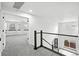 Upstairs hallway with modern railings leads to a carpeted bedroom at 2078 Goldfinch Ct, Longmont, CO 80503