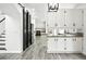 White kitchen features modern appliances and is adjacent to the staircase at 2078 Goldfinch Ct, Longmont, CO 80503
