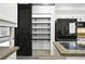 View of kitchen pantry with shelving and adjacent modern stainless steel refrigerator at 2078 Goldfinch Ct, Longmont, CO 80503