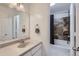 Bathroom features a vanity with a sink, a mirror, and a shower-tub combo with decorative tiling at 7897 Allison Way # 304, Arvada, CO 80005