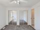 Bedroom featuring carpet, mirrored closet doors, access to a second bedroom and ensuite bathroom at 7897 Allison Way # 304, Arvada, CO 80005