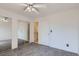 Carpeted bedroom with mirrored closets, ceiling fan, and a door leading to an ensuite bathroom at 7897 Allison Way # 304, Arvada, CO 80005