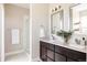 Well-lit bathroom featuring dual sinks, modern fixtures, and a glass-enclosed shower, offering a spa-like experience at 2869 Kingston St, Denver, CO 80238