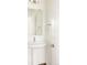 Elegant powder room featuring a pedestal sink with modern fixtures and a decorative mirror, offering a stylish touch at 2869 Kingston St, Denver, CO 80238