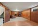 Finished basement featuring a fireplace, carpet, wood paneling, and a door leading to stairs at 6705 Nelson St, Arvada, CO 80004