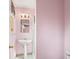 Traditional bathroom featuring pedestal sink, mirror, and glass shower in a cozy space with pink walls at 6705 Nelson St, Arvada, CO 80004