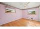 Pink bedroom with hardwood floors, floral wallpaper border, and natural light from two windows at 6705 Nelson St, Arvada, CO 80004