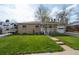 Charming brick home with well-manicured lawn and a covered front porch at 6705 Nelson St, Arvada, CO 80004