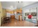 Cozy kitchen with wood cabinets, white appliances, and an adjoining sunroom at 6705 Nelson St, Arvada, CO 80004