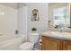 Bathroom featuring a shower-tub combo, tiled walls, toilet, and a single sink vanity at 12832 Mayfair Way # A, Englewood, CO 80112