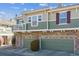 A lovely view of the home with stone accents, charming windows, and individual garage spaces at 12832 Mayfair Way # A, Englewood, CO 80112