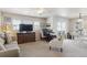 Bright living room with a large TV, neutral tones, and a sliding glass door to a balcony at 12832 Mayfair Way # A, Englewood, CO 80112