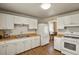 Efficient kitchen with white cabinets and wood laminate flooring at 3045 Xanadu St, Aurora, CO 80011