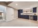 Finished basement bar area with sleek cabinetry, beverage cooler, and stylish lighting at 6005 Beeler St, Denver, CO 80238
