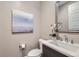 Elegant powder room with modern fixtures, decorative mirror, and artwork at 6005 Beeler St, Denver, CO 80238