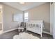 Charming bedroom features a white crib and accent chair, bathed in natural light from the nearby window at 6005 Beeler St, Denver, CO 80238