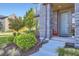 Front porch features a brick facade, landscaping, and a red chair at 6005 Beeler St, Denver, CO 80238