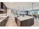 Open kitchen featuring large island, barstool seating, and a view to the dining room and living room at 6005 Beeler St, Denver, CO 80238