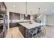 Modern kitchen featuring a large island with seating, stainless steel appliances, and stylish pendant lighting at 6005 Beeler St, Denver, CO 80238