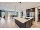 Bright, open kitchen featuring an island with pendant lights, stainless steel appliances, and an adjacent dining area at 6005 Beeler St, Denver, CO 80238
