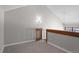 A carpeted bedroom with grey walls and a partial railing, light fixture, and partial wood wall at 14046 E Stanford Cir # I11, Aurora, CO 80015