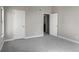 An empty bedroom with gray walls, carpet, white trim, a window and closet/bathroom door at 14046 E Stanford Cir # I11, Aurora, CO 80015