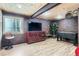 Finished basement with a brick accent wall, entertainment center, and a foosball table at 1421 Rustic Dr, Longmont, CO 80504