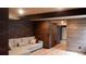 Finished basement features brick walls, wood-look flooring, and a comfortable sectional sofa at 1421 Rustic Dr, Longmont, CO 80504